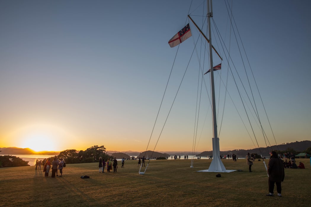 People watch on as the sun rises at the Upper Marae on Waitangi Day. 6 February 2017.