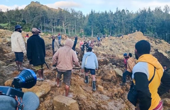 People gather at the site of a landslide in Maip Mulitaka in Papua New Guinea's Enga Province on May 24, 2024. Local officials and aid groups said a massive landslide struck a village in Papua New Guinea's highlands on May 24, with many feared dead. (Photo by AFP)
