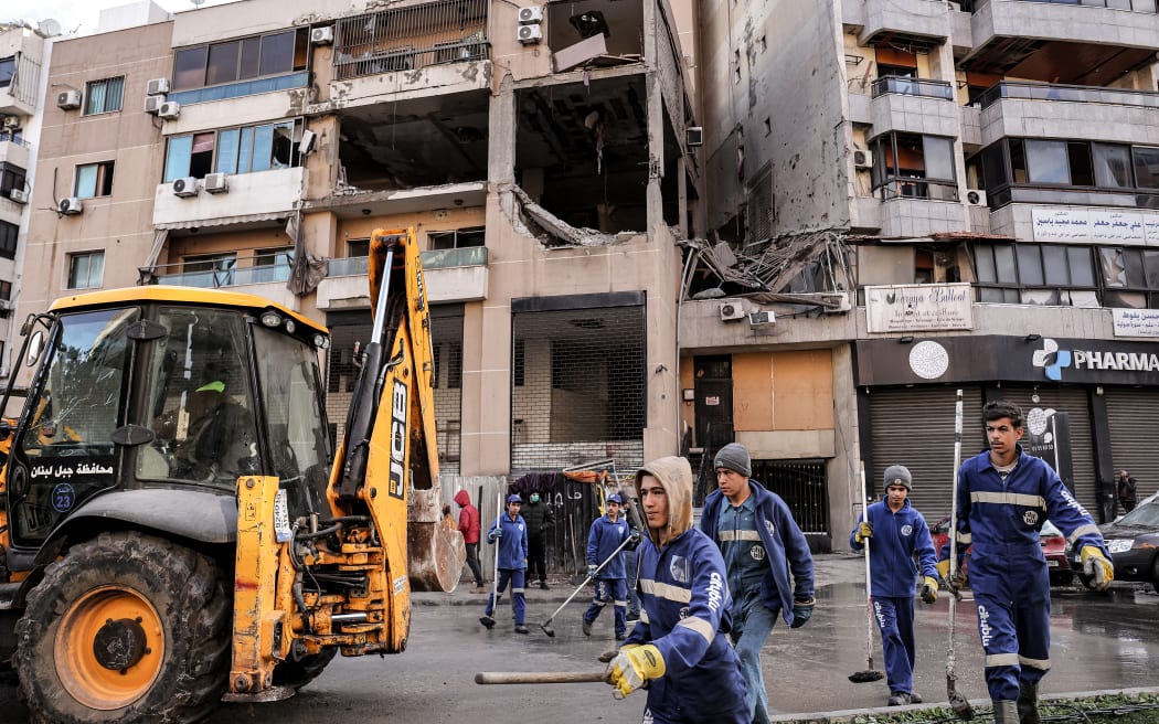 Municipal workers clean the street by the building that was hit by a drone strike attributed to Israel targeting Hamas deputy leader Saleh al-Aruri in the southern suburb of Beirut on January 3, 2024. Aruri, exiled from his village Arura since he was released from an Israeli jail in 2010, was killed in a drone strike on a southern Beirut suburb that Lebanese officials said was carried out by Israel.