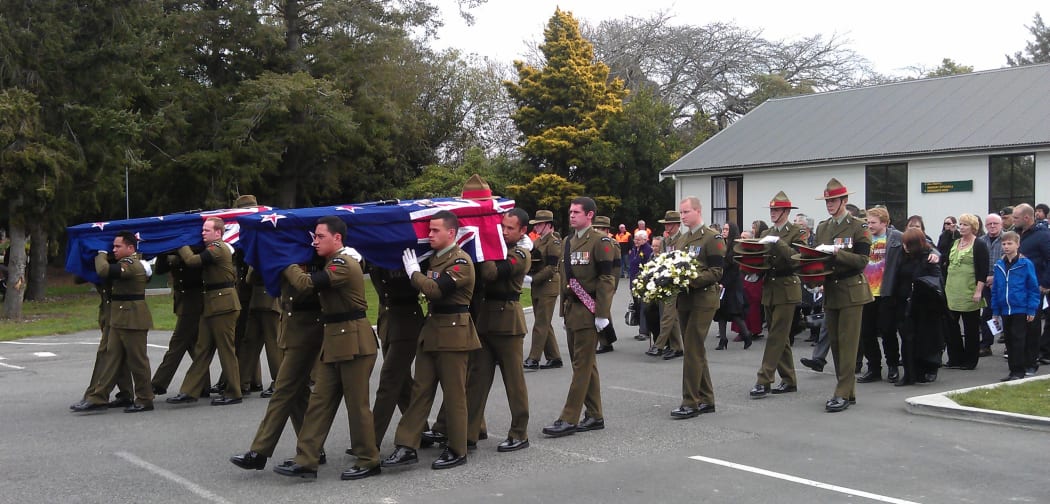 A procession with the caskets leaving the service.