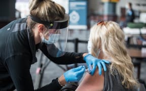 FOXBOROUGH, MA - JANUARY 15: A woman receives the COVID-19 vaccine at Gillette Stadium on January 15, 2021 in Foxborough, Massachusetts.