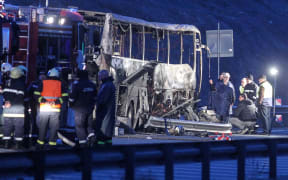 Officials work at the site of a bus accident, in which at least 45 people were killed, on a highway near the village of Bosnek, south of Sofia, on November 23, 2021.