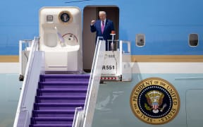 US President Donald Trump gestures as he exits his plane upon arriving at the airport in Riyadh on May 13, 2025. (Photo by Brendan Smialowski / AFP)