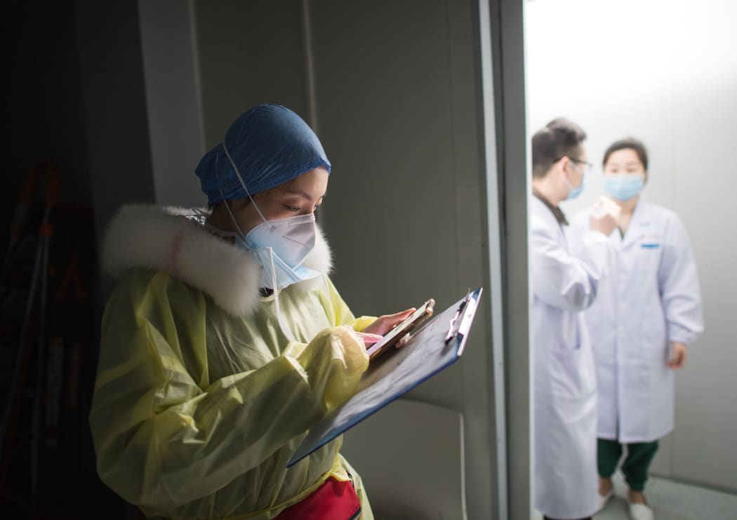 Nurse Sun Chun reads medical records at a hospital in Wuhan, yesterday.