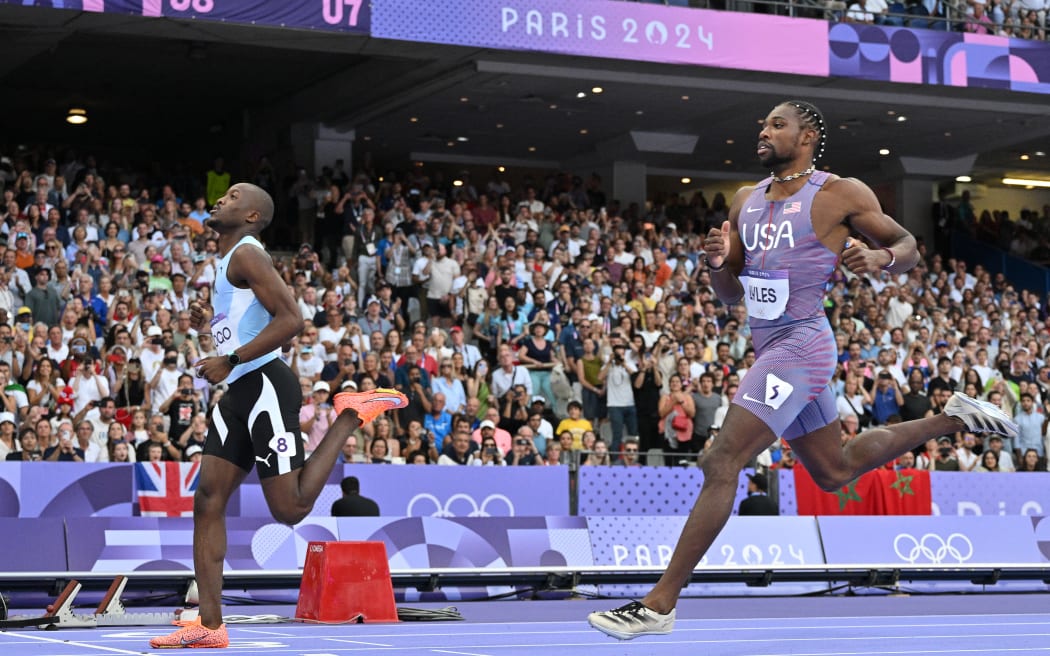 Botswana's Letsile Tebogo, left, crosses the finish line ahead of US's Noah Lyles in the men's 200m semi-final at the Paris Olympics.