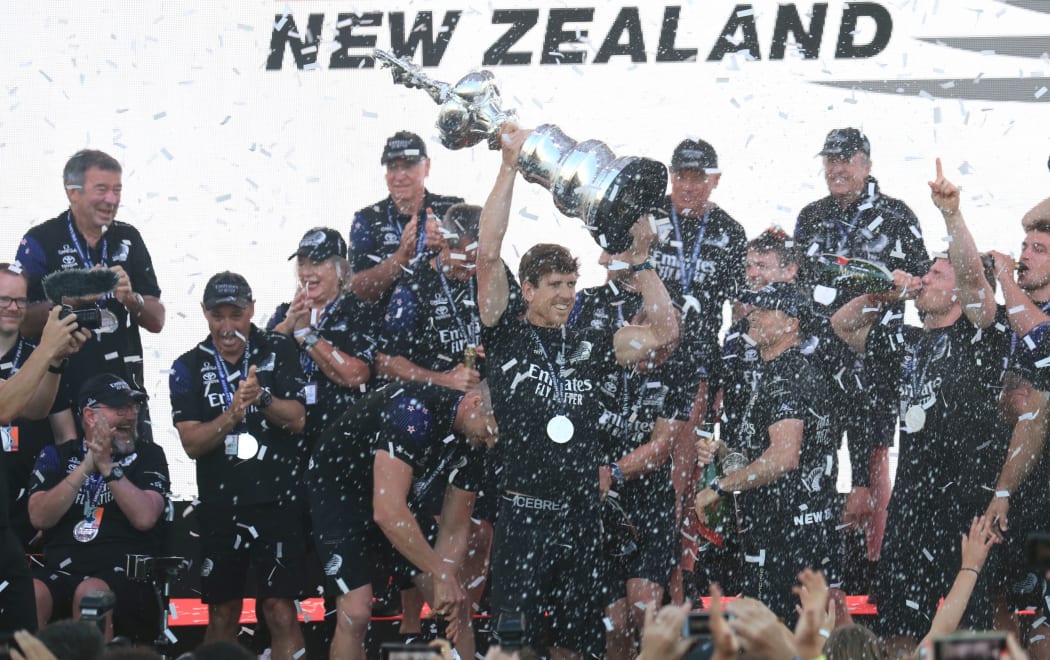 Team New Zealand's skipper Peter Burling (C) holds the America's Cup, affectionately known as the Auld Mug, after winning the 36th America's Cup against Luna Rossa Prada in Auckland on March 17, 2021.