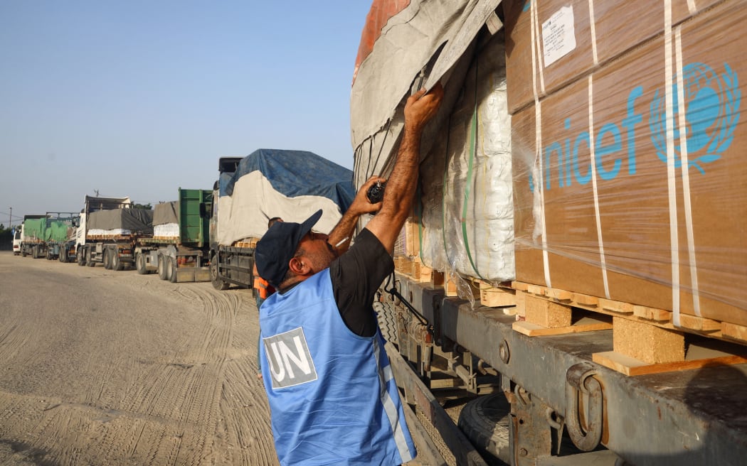 A United Nations employee checks humanitarian aid on a convoy of lorries entering the Gaza Strip from Egypt via the Rafah border crossing on 21 October 2023.