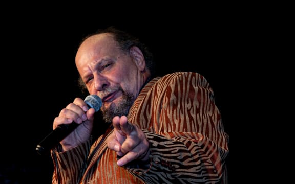 Older man singing into microphone