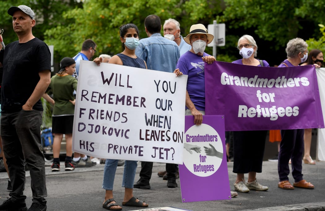 People protest government detention of refugees at the detention centre where Serbia's tennis champion Novak Djokovic is reported to be staying in Melbourne after Australian officials see-sawed on his entry.