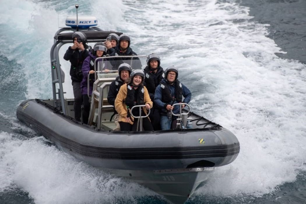 A media team on their way out to HMNZS Aotearoa.