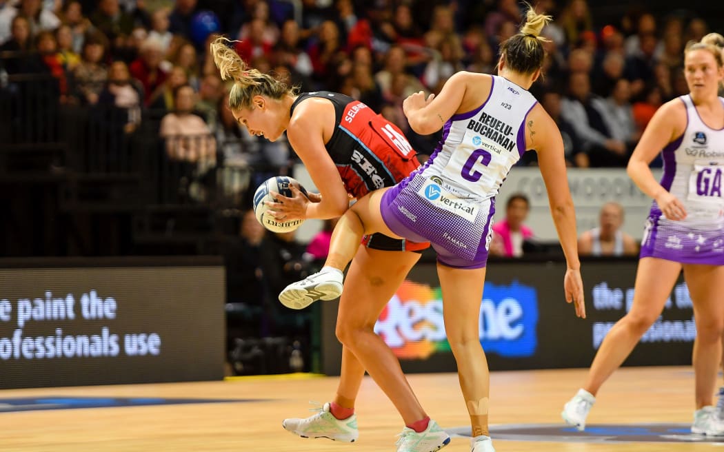 Te Paea Selby-Rickit of the Tactix tussles wuth Mila Reuelu-Buchanan of the Stars.