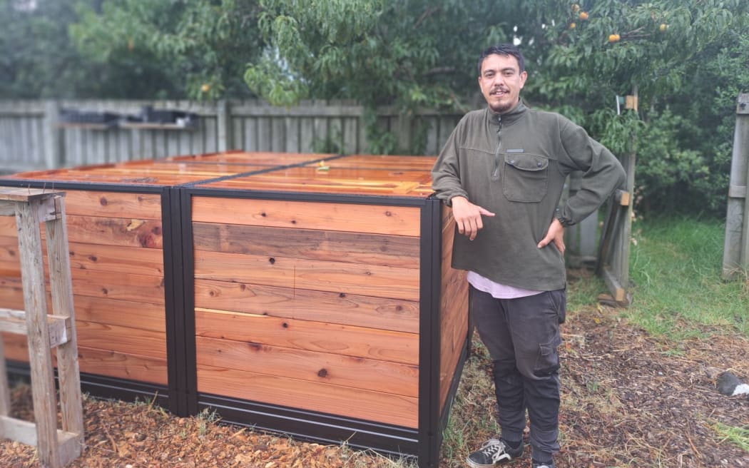 Rata Taiwhanga next to one of the hub's carbon cycle compost bins.