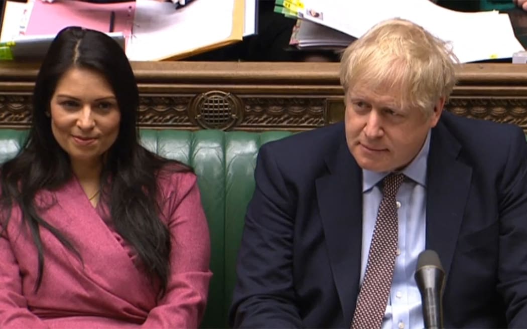 A video grab from footage broadcast by the UK Parliament's Parliamentary Recording Unit (PRU) shows Britain's Prime Minister Boris Johnson (R) sits next to Britain's Home Secretary Priti Patel (L) on the front bench during Prime Minister's Question time (PMQs) in the House of Commons in London on March 4, 2020. (Photo by various sources / AFP) / RESTRICTED TO EDITORIAL USE - MANDATORY CREDIT " AFP PHOTO / PRU " - NO USE FOR ENTERTAINMENT, SATIRICAL, MARKETING OR ADVERTISING CAMPAIGNS