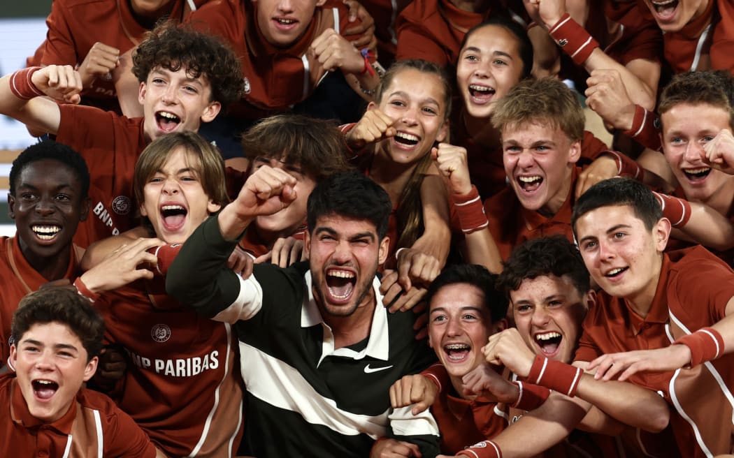 Spain's Carlos Alcaraz celebrates with ball boys and girls after winning against Italy's Jannik Sinner at the end of their men's singles final match on day 15 of the French Open tennis tournament on Court Philippe-Chatrier at the Roland-Garros Complex in Paris on June 8, 2025. (Photo by Thibaud MORITZ / AFP)