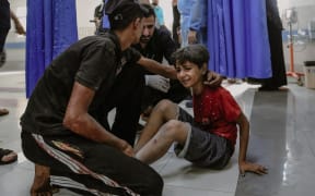 A young injured boy weeps at the overcrowded Al-Shifa Hospital in Gaza City in the aftermath of an Israeli airstrike. Doctors at the hospital are encountering significant difficulties in delivering care due to its current capacity.