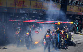 Mechanics deal with the smoke coming out of Red Bull Racing's Dutch driver Max Verstappen car during the Australian Formula One Grand Prix at Albert Park Circuit in Melbourne on March 24, 2024.