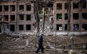 A man walks in front of a destroyed building after a Russian missile attack in the town of  Vasylkiv, near Kyiv, on February 27, 2022.