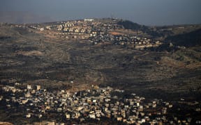 A picture, taken from Nablus, shows in the foreground the Palestinian West Bank village of Azmout and in the background the Jewish settlement of Elon Moreh