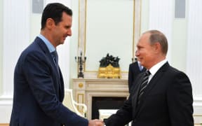 Russian President Vladimir Putin (R) shakes hands with his Syrian counterpart Bashar al-Assad (L) during their meeting at the Kremlin in Moscow on October 20, 2015.