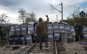 Macedonian police cordon during clashes with refugees protesting against the building of a metal fence at the Greek-Macedonian border
