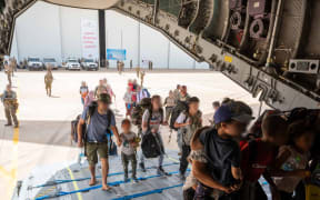 This handout photograph taken on April 23, 2023 and released by the Etat Major des Armees (French defence staff) shows French and other nationalities people as they embark at French military air base in Khartoum to fly to Djibouti on April 23, during the "Sagittaire" evacuation of around 100 people from Sudan on the first French flight out of the war-hit country after a "complicated" rescue operation.