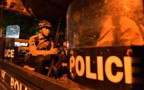 A Myanmar riot policemen sits in a truck on a street in Yangon's Mingalar Taung Nyunt township early on May 10, 2017, after scuffles broke out between Buddhist nationalists and Muslims.