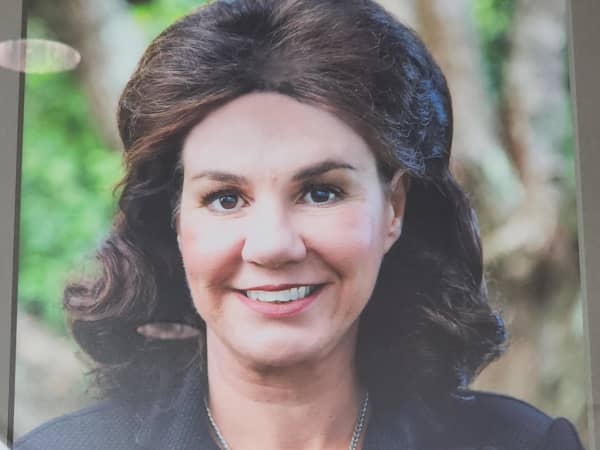 A framed photograph of a well-groomed woman in her early 60s, who is smiling, Pauline Hanna.