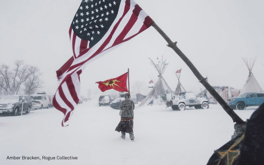 People carry an American and a Mohawk Warrior Society flag at a protest camp against the Dakota Access Pipeline.