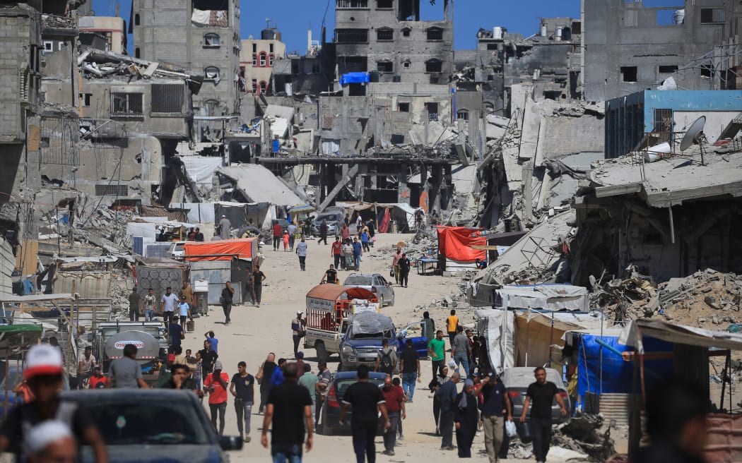 Displaced Palestinians walk along a devastated street in Khan Yunis in the southern Gaza Strip on May 24, 2024, as conflict between Israel and Hamas militants continues.