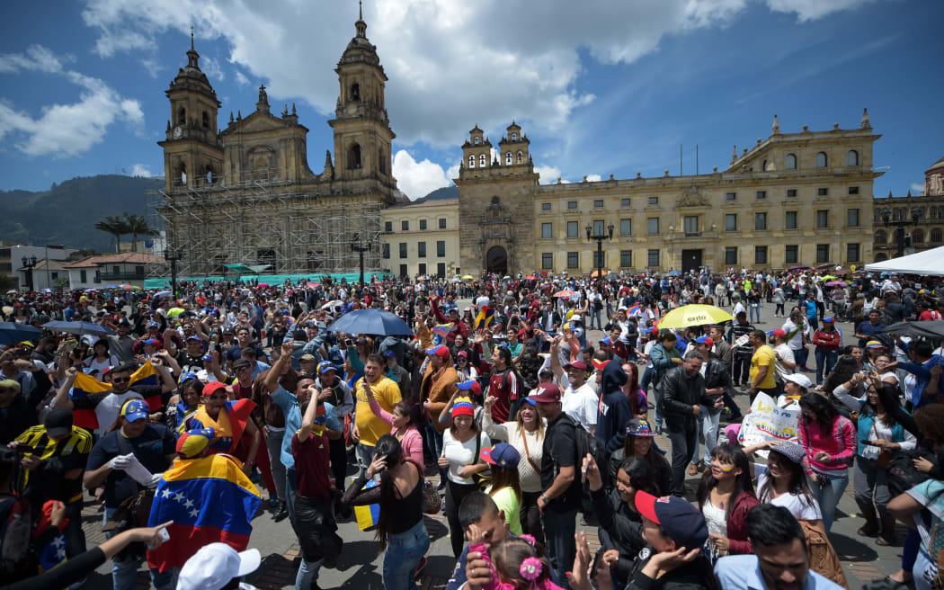Opposition activists celebrate outside polling stations after taking part in an opposition-organized vote to measure public support for Venezuelan President Nicolas Maduro's plan to rewrite the constitution.