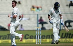 New Zealand's Matt Henry(L) celebrates after taking the wicket of India's Murali Vijay(R) during the first day of the second Test match between India and New Zealand at The Eden Gardens Cricket Stadium in Kolkata on September 30,