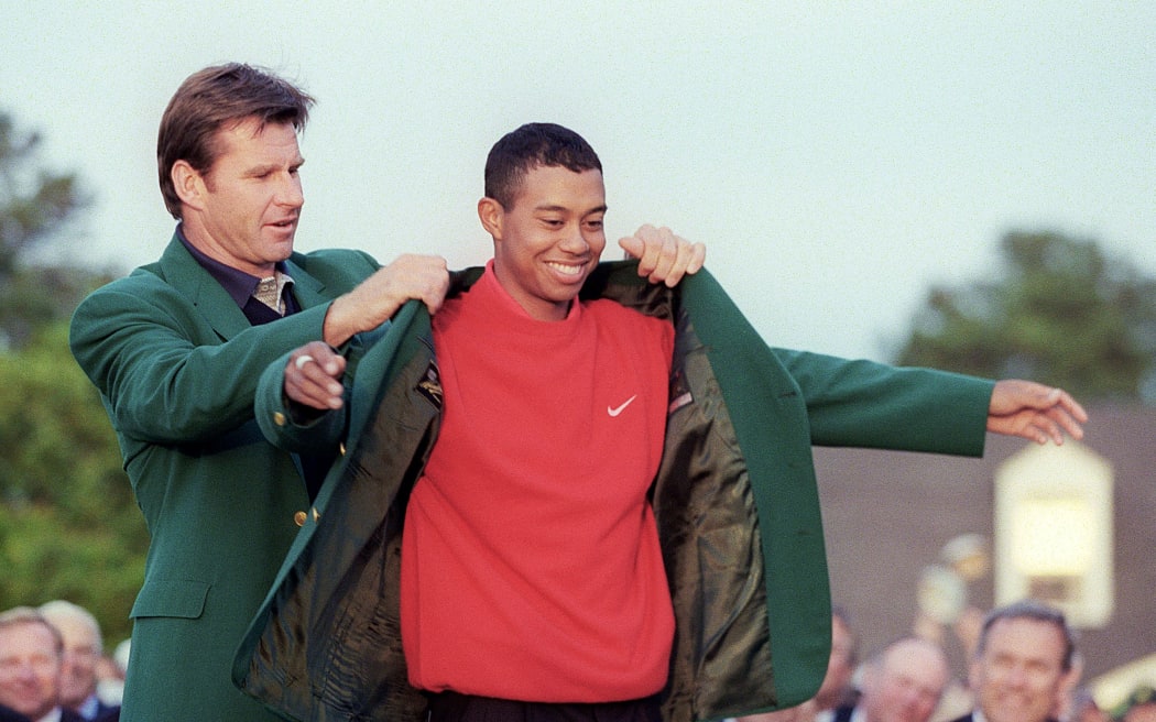 Tiger Woods receives the Masters green jacket from 1996 Masters champion Nick Faldo after Woods won the 1997 tournament.