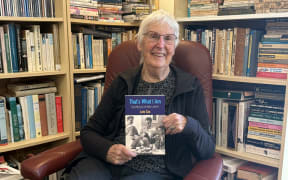 Lois Cox, holding a copy of her new book That's What I Am.
