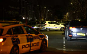 A car is seen behind police cordon after a suspected corrosive substance attack in south London on February 1, 2024. UK police were on Thursday hunting a suspect who attacked a woman and her two young daughters with a corrosive substance on a south London residential street. Police named the suspect as 35-year-old Abdul Ezedi, believed to be from the Newcastle area in northeastern England and urged the public not to approach him. (Photo by HENRY NICHOLLS / AFP)