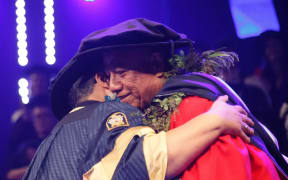 Pro-Chancellor Caren Rangi and Sopolemalama Filipe Tohi embrace after he is presented with the doctorate.