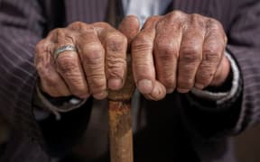 hand of a old man holding a cane