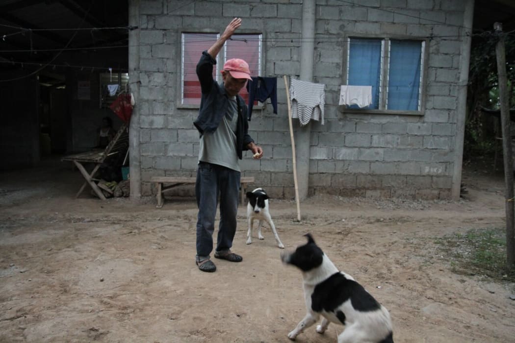 Francisco B. Milallos plays with his dogs as the sun rises