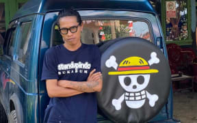 Radinal Muhtar paints the One Piece emblem on the back of his car to express his frustration with the government.