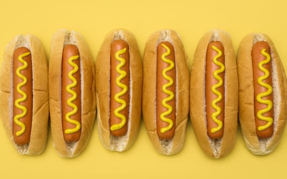 Hot dogs against a plain background. (Photo by SCIENCE PHOTO LIBRARY / R3F / Science Photo Library via AFP)