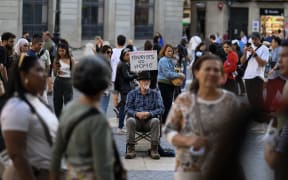 An activist in the Plaza de San Jaime, in the historic center, shows a sign with the phrase ''Tourists go home'' in Barcelona, Spain, on November 10, 2024. (Photo by Jorge Mantilla/NurPhoto) (Photo by Jorge Mantilla / NurPhoto / NurPhoto via AFP)