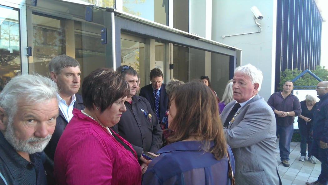 Families of Pike River victims outside the courthouse, including spokesperson Bernie Monk in grey jacket.