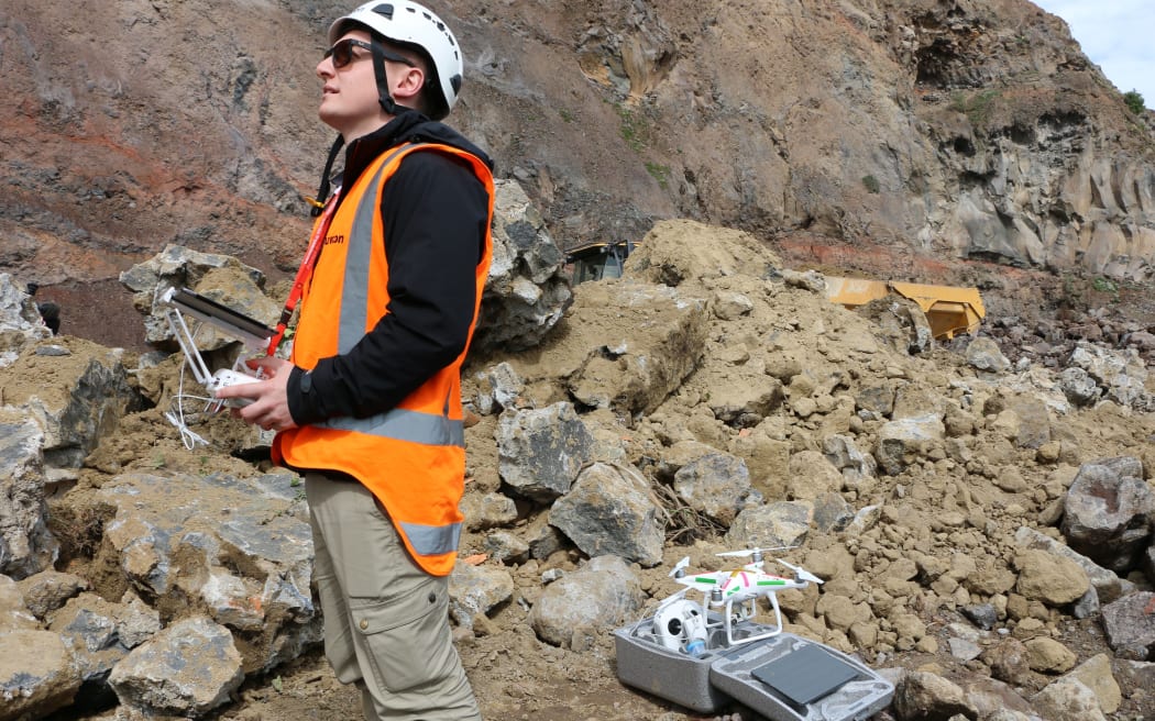 A drone pilot gets ready to take elevated shots of the cliff face.