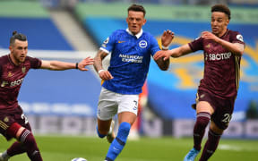 Leeds United's English midfielder Jack Harrison (L) and Leeds United's Brazilian-born Spanish striker Rodrigo (R) close in on Brighton's English defender Ben White during the Premier League football match at Brighton, southern England on May 1, 2021.