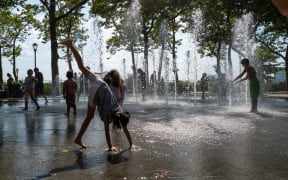 Children cool off in a fountain in a park on a hot afternoon in Manhattan on July 19, 2022 in New York City.