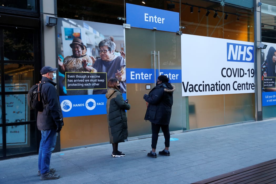 Members of the public queue to enter a new coronavirus mass vaccination centre at Stratford shopping centre in east London on January 25, 2021.