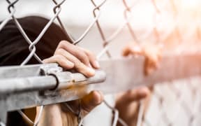 Woman hand holding on chain link fence for remember Human Rights Day concept.