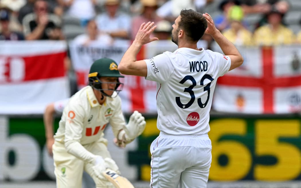 England’s Mark Wood reacts after Australia’s Brendan Doggett hits a shot during the first Ashes Test, Perth, 2025.