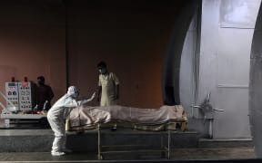 A relative of a Covid-19 victim prays before the cremation, at Nigambodh Ghat crematorium in New Delhi, India on April 07, 2021.