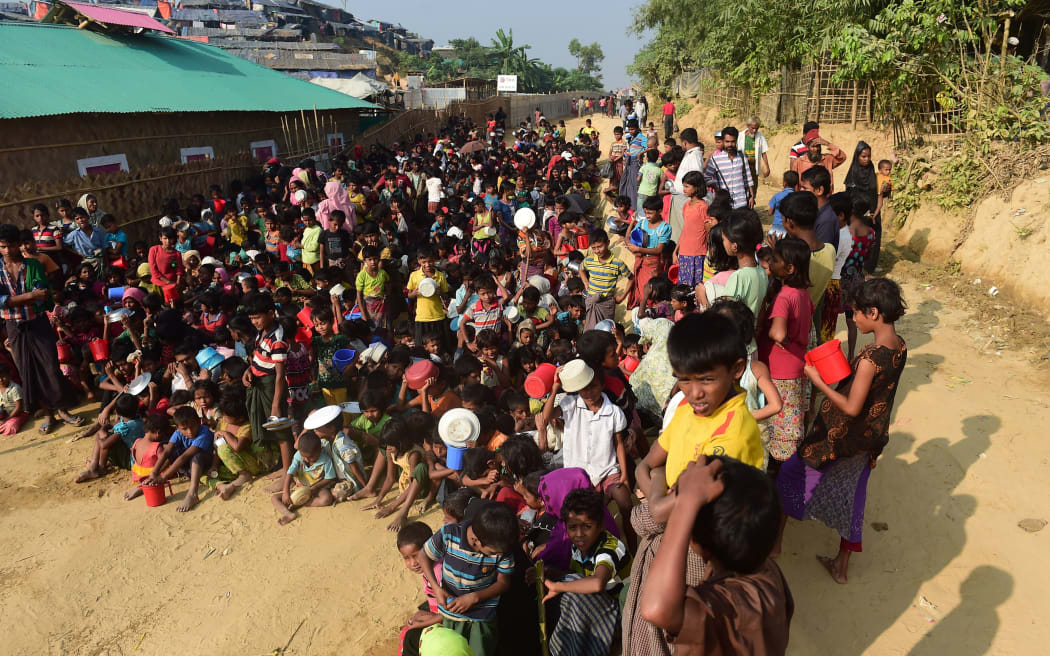 Rohingya refugee children wait for food at a food distribution center in Thankhali refugee camp in the Bangladeshi district of Ukhia.
