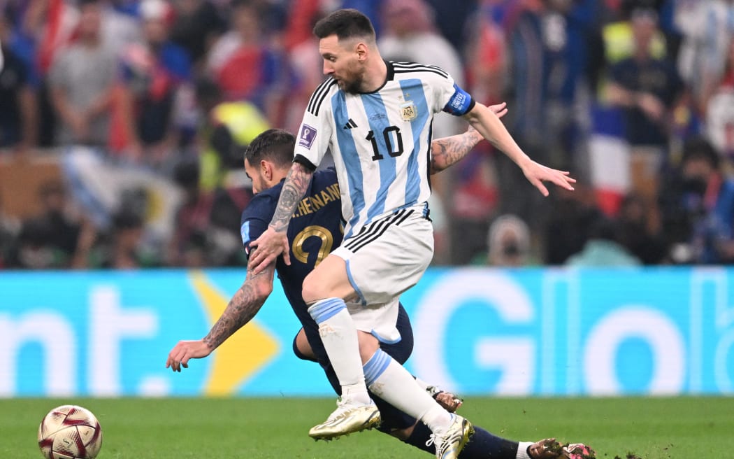 France's defender #22 Theo Hernandez (L) fights for the ball with Argentina's forward #10 Lionel Messi during the Qatar 2022 World Cup final football match between Argentina and France at Lusail Stadium in Lusail, north of Doha on December 18, 2022.